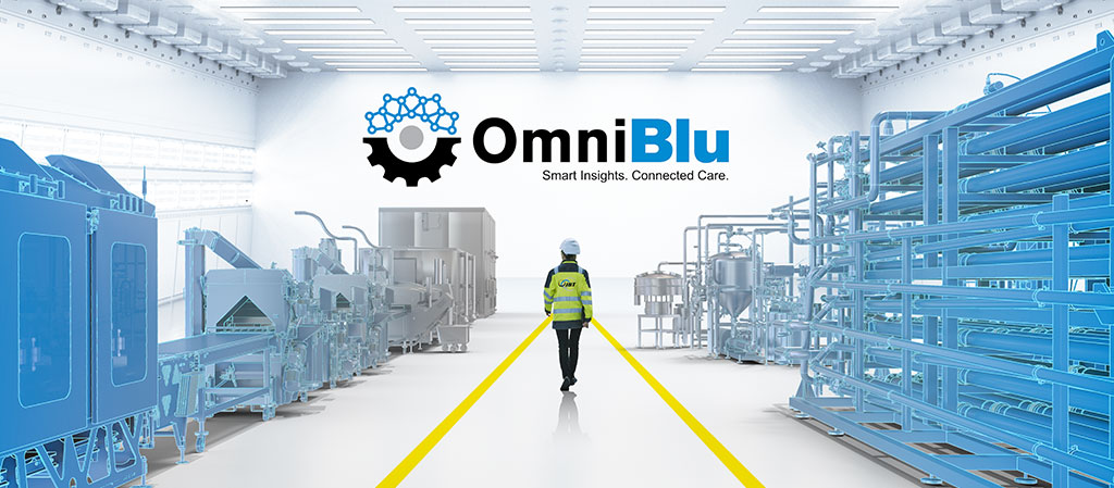 Person walking through a digital factory floor with JBT's OmniBlu logo hovering overhead, symbolizing innovation and advanced technology in food production.