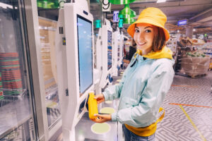 young woman purchasing Functional Beverages at shelf checkout